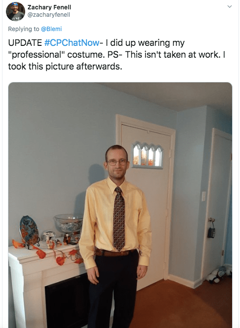 A picture of Zach as a professional- zach in yellow dress shirt, brown tie, and black slacks with a brown belt 